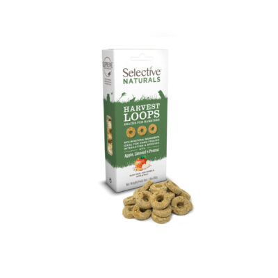 A box of Selective Naturals Harvest Loops, a snack for hamsters and gerbils, in apple, linseed, and peanut flavor. The packaging is white and green, featuring silhouettes of small animals and key product benefits. In front of the box, several beige, ring-shaped treats are displayed.